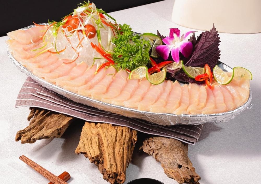 Những l&aacute;t sashimi c&aacute; tầm tươi r&oacute;i điểm th&ecirc;m l&aacute; t&iacute;a t&ocirc; xanh mướt, tạo n&ecirc;n một tổng thể vừa tinh tế vừa hấp dẫn (Nguồn: Fanpage An Sơn H&ocirc;̀)